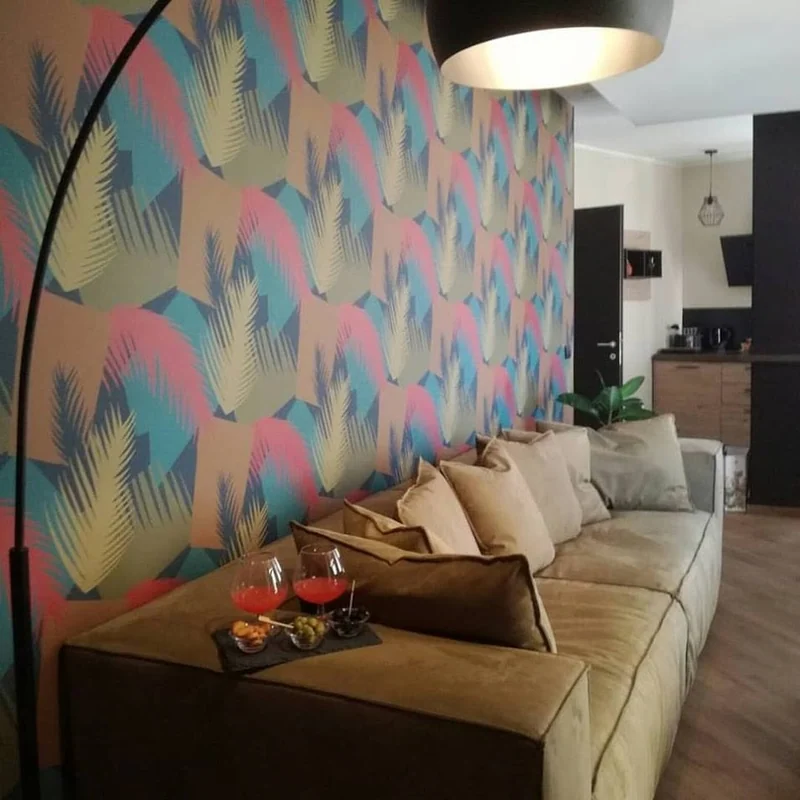 Divano con cuscini davanti a una parete decorata