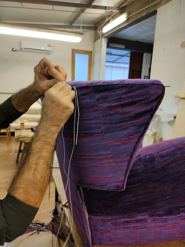 Lavorazione manuale della tappezzeria di una poltrona